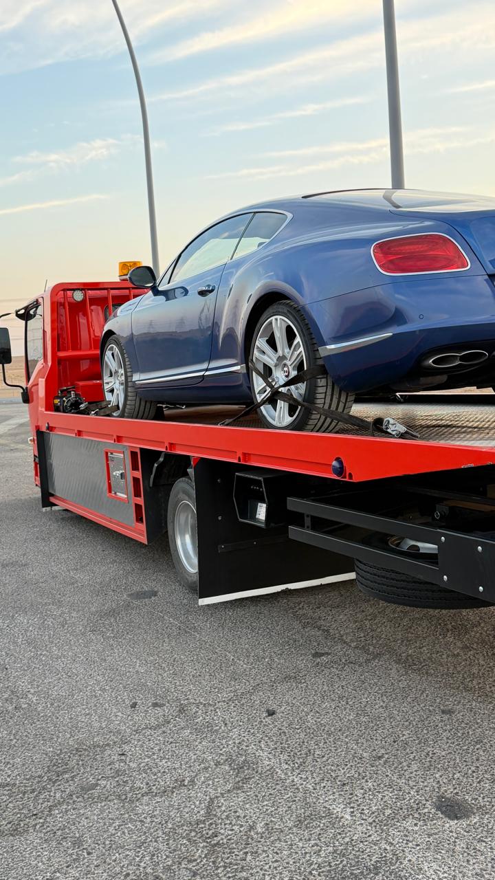 نقل سيارة بنتلي زرقاء فاخرة على سطحة حمراء